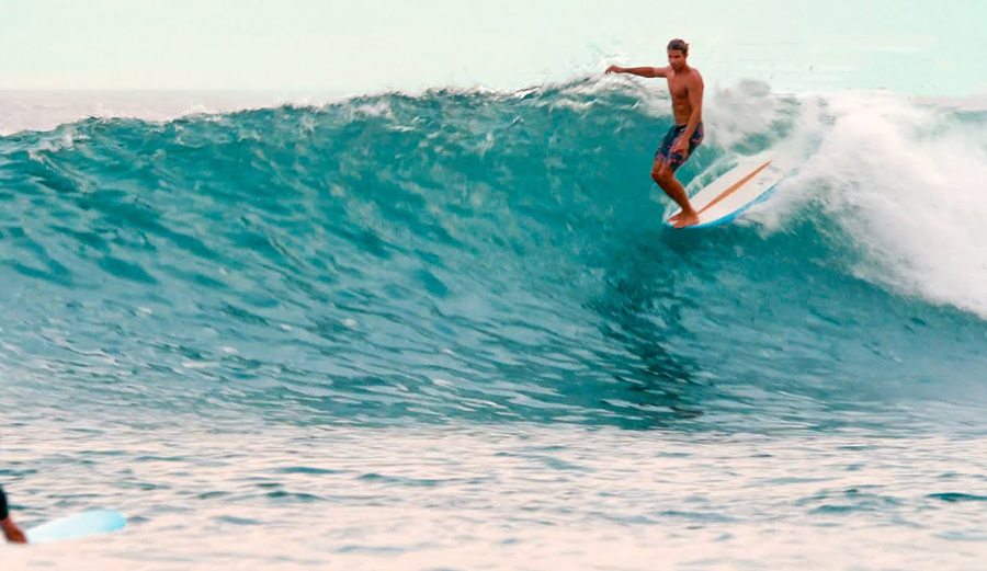 A longboarder rides a wave in Mexico