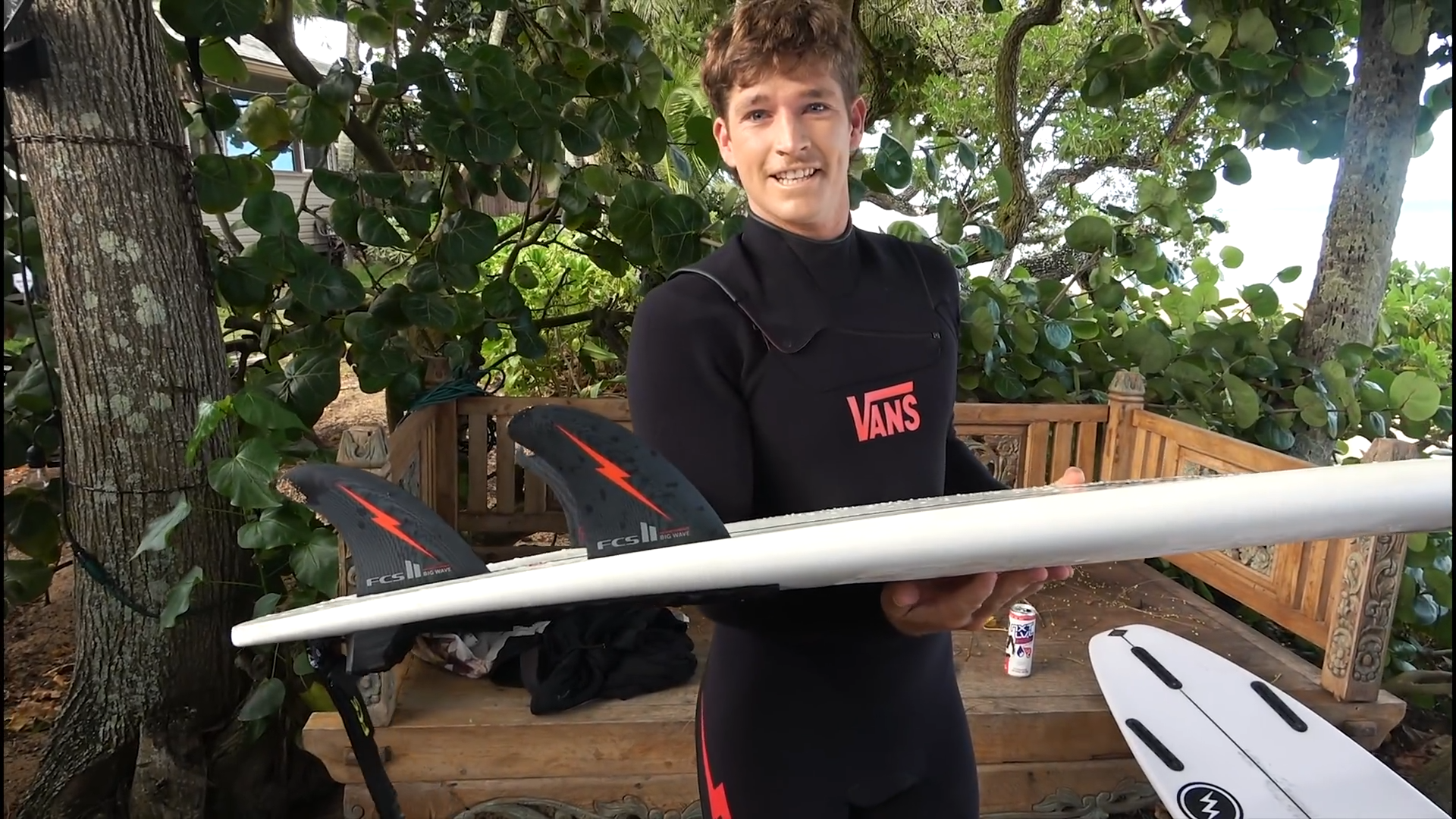 Nathan holds up his surfboard with his new FCS II fin set-up.