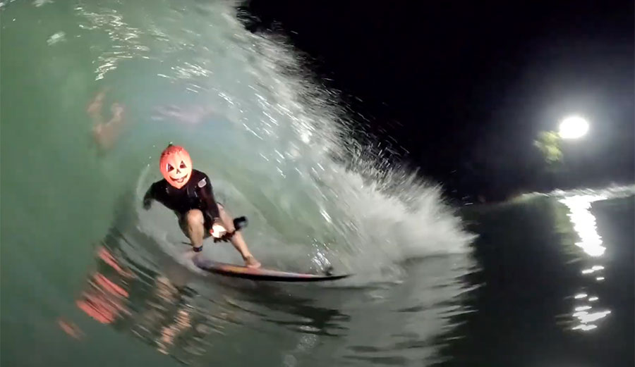 Mason Ho surfing in a pumpkin head mask