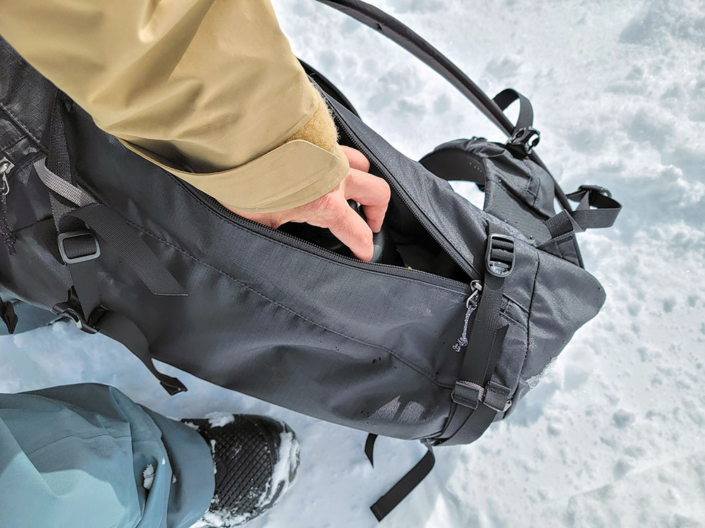 opening the main compartment of the patagonia descensionist backpack using the side zipper access