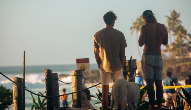 guys in boardshorts watching waves