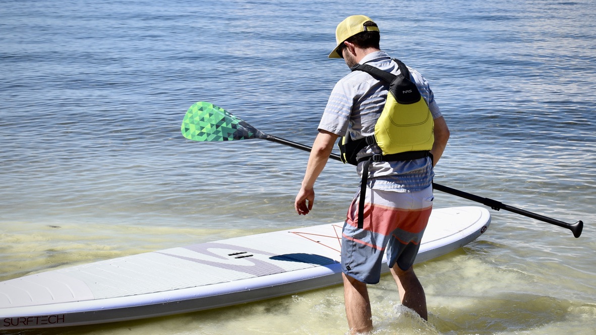 man paddle boarding on lake tahoe with NRS Ninja life jacket