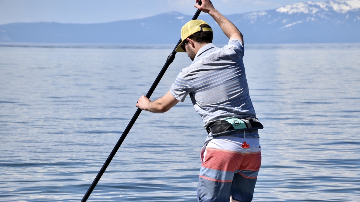 man paddle boarding on lake tahoe with bote inflatable belt life jacket