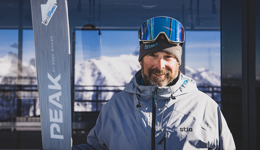 a man holding skis poses for a picture