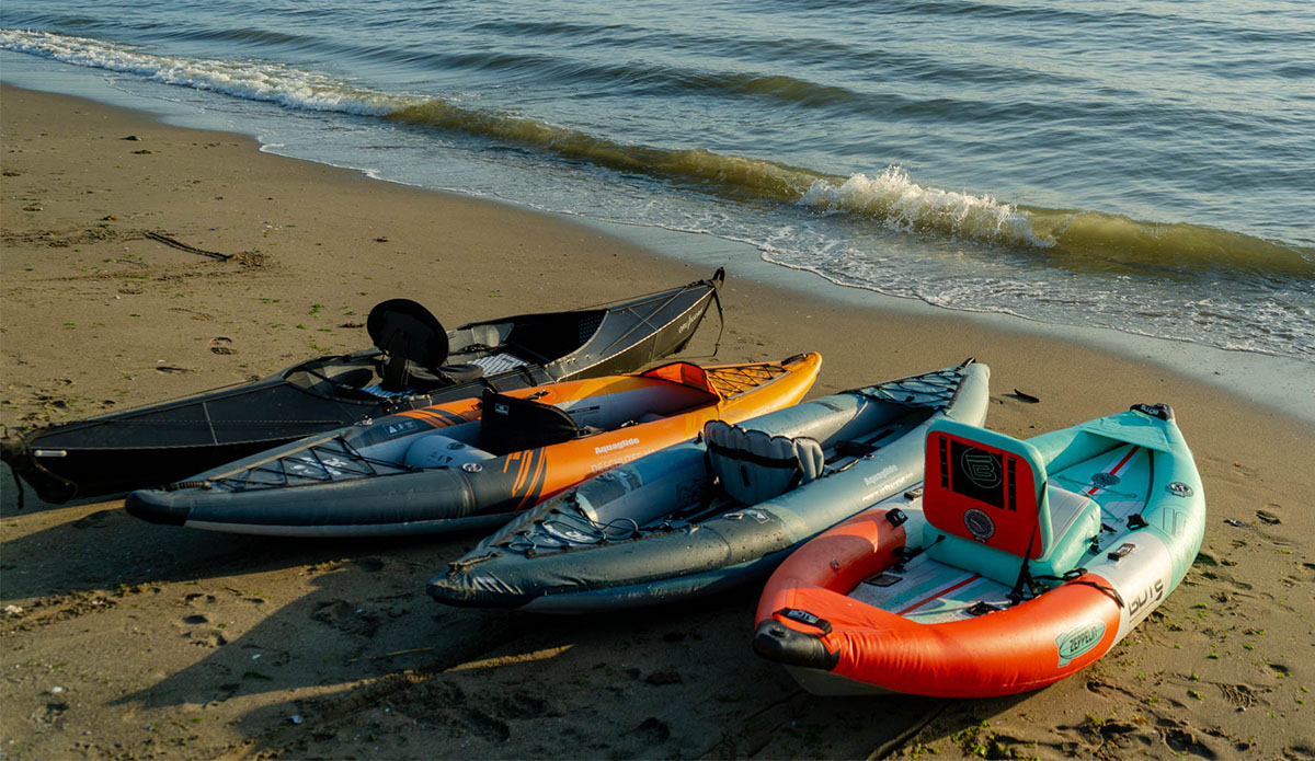 some of the kayaks we reviewed the best inflatable kayaks for 2023, shown here lined up on the beach.
