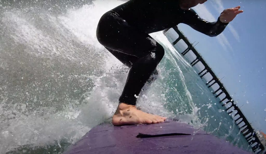 Travis Logie rides a sandpaper surfboard.