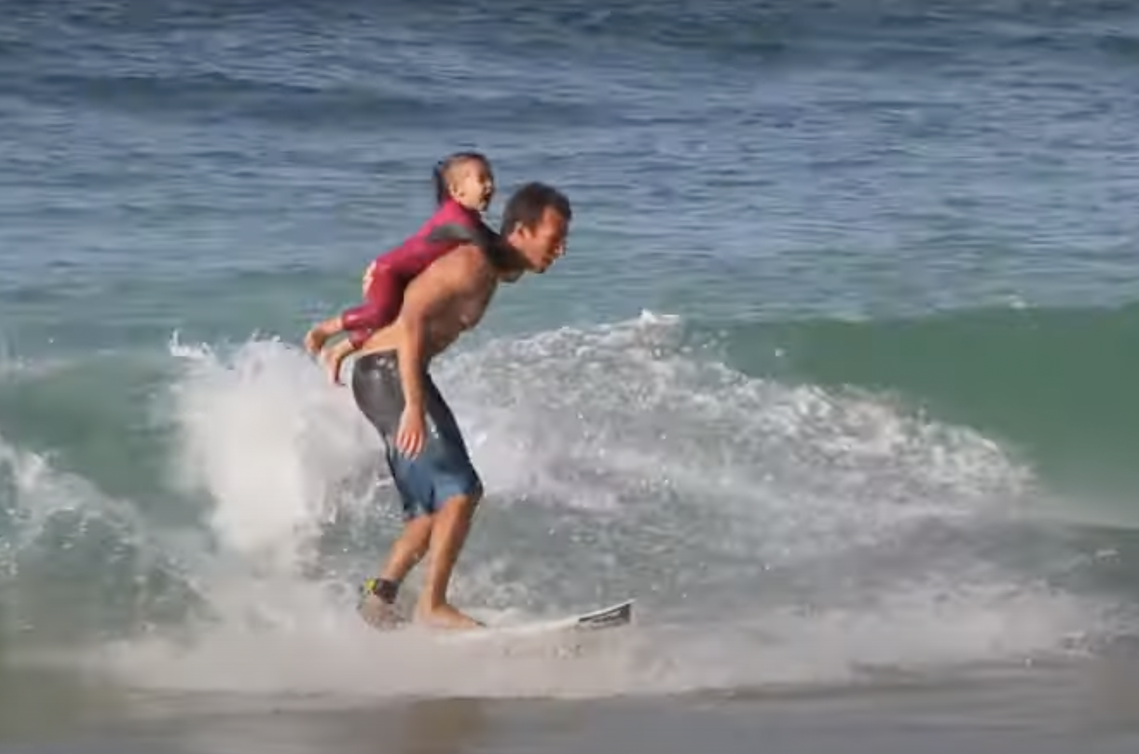 Cory Lopez surfing with his daughter Alana