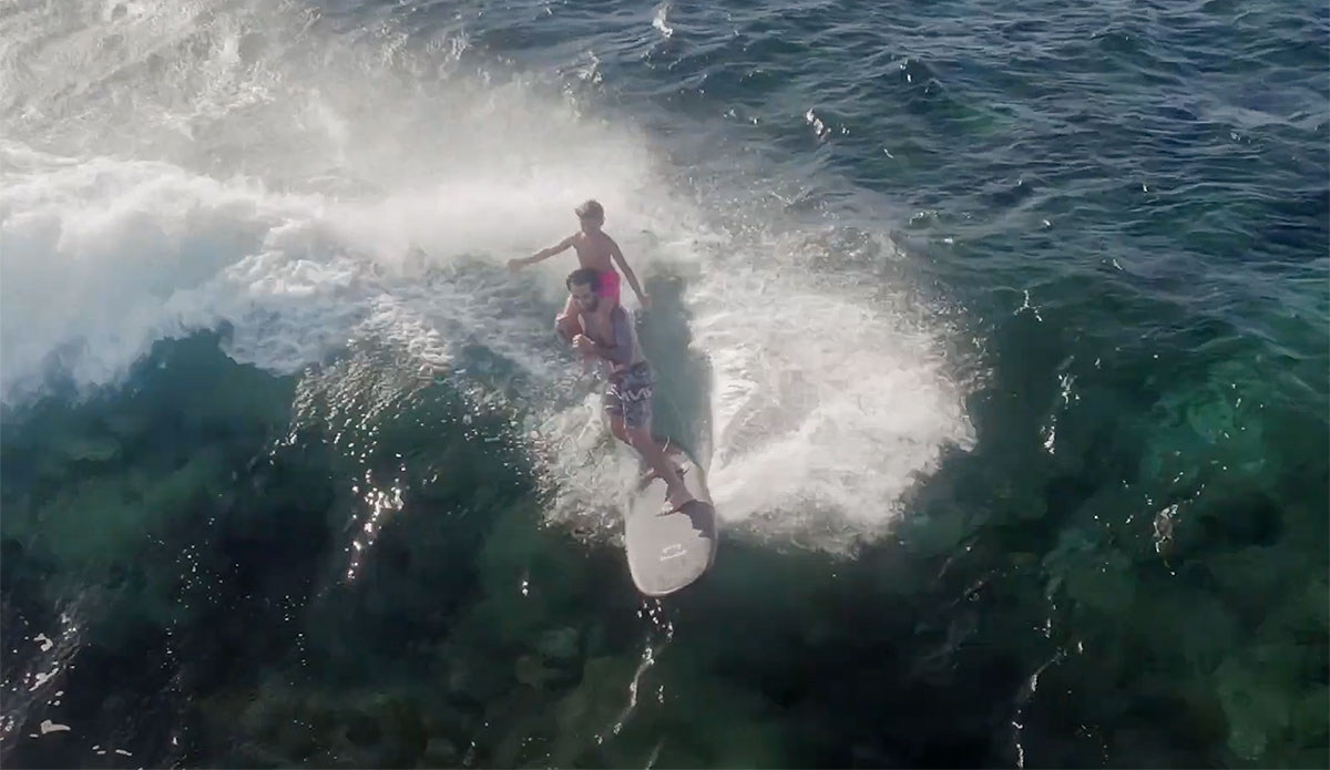 Billy Kemper surfing with his son on Tavarua