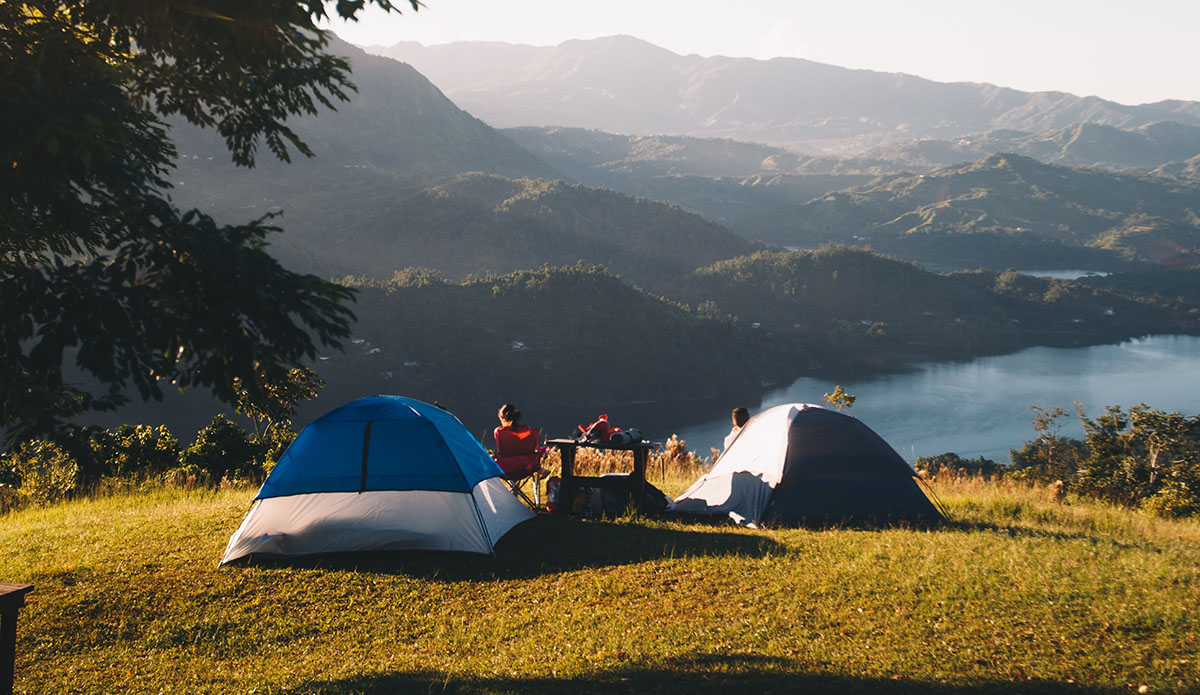 a campsite overlooking a mountain view and lake. photo by Victor Larracuente on Unsplash