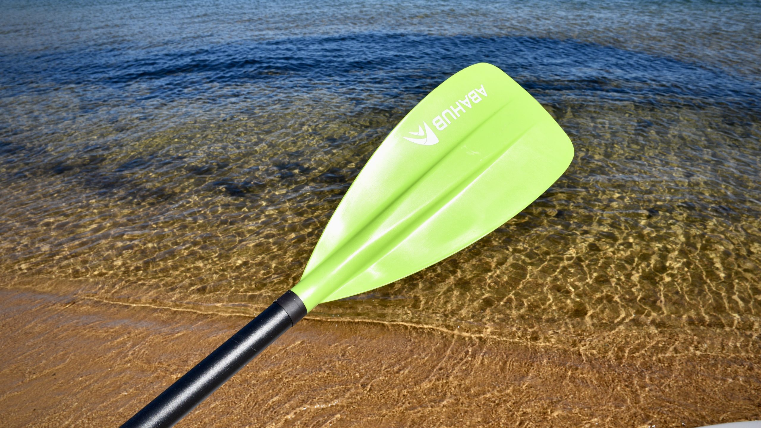 The bright yellow/green Abuhub SUP paddle in front of Lake Tahoe