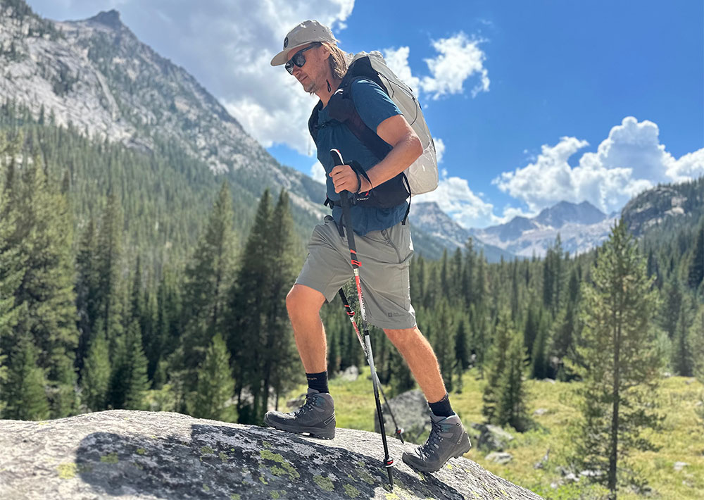 a hiker climbs a rock in the sawtooth mountains of idaho while testing hiking boots