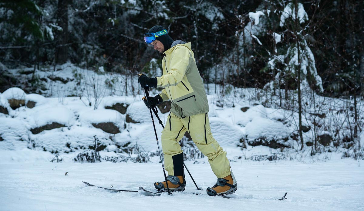 a splitboarder skinning up a trail using the Burton Kalausi jacket and pants