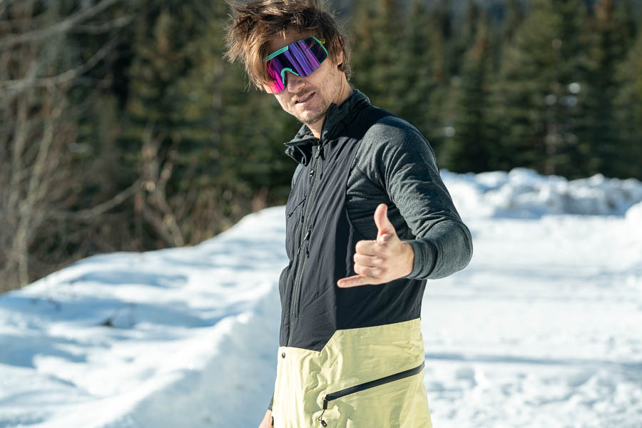 a snowboarder doing a shaka while reviewing the Burton [AK} Kalausi bib pants
