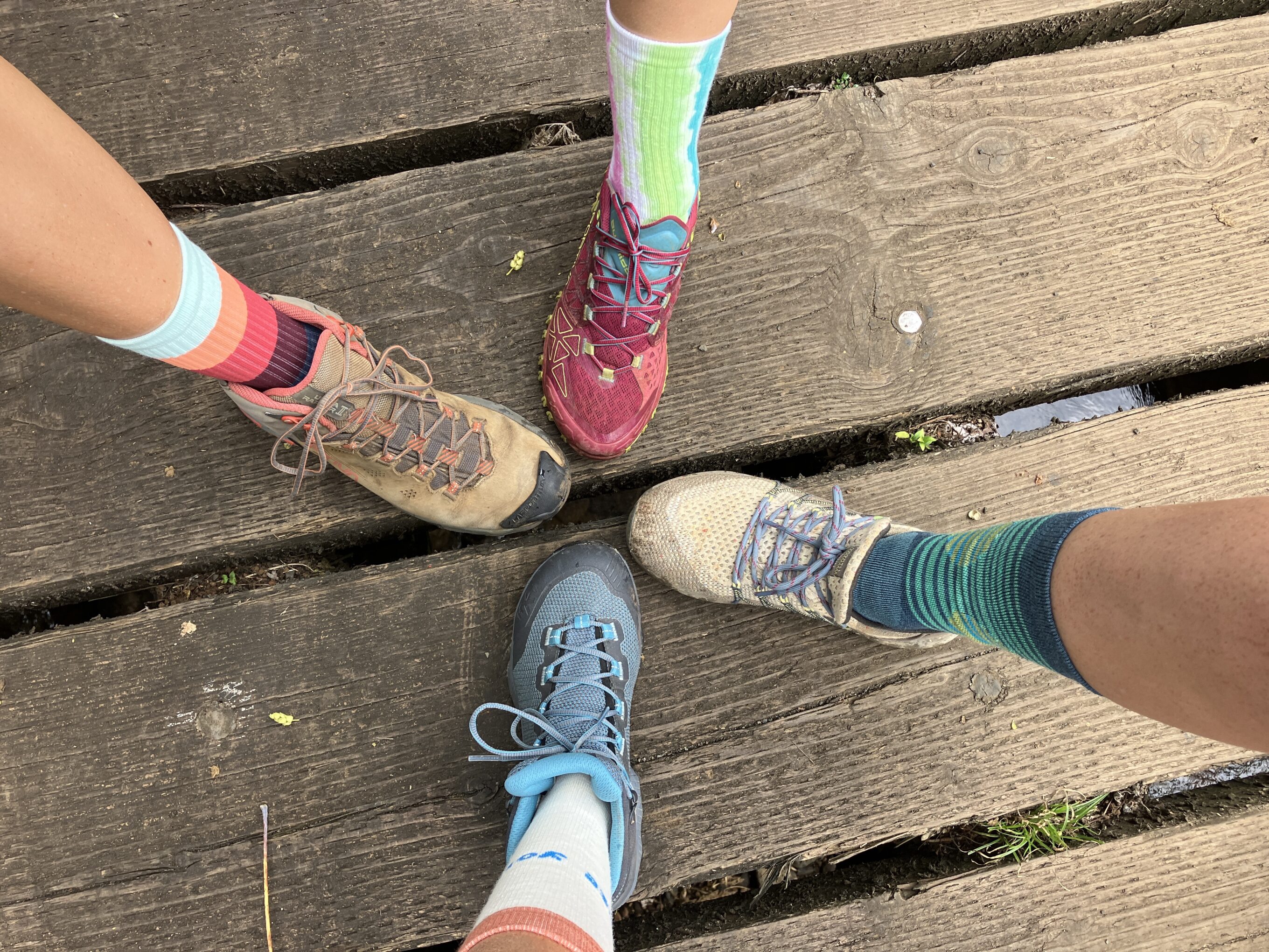 four feet wearing shoes and hiking socks in the frame