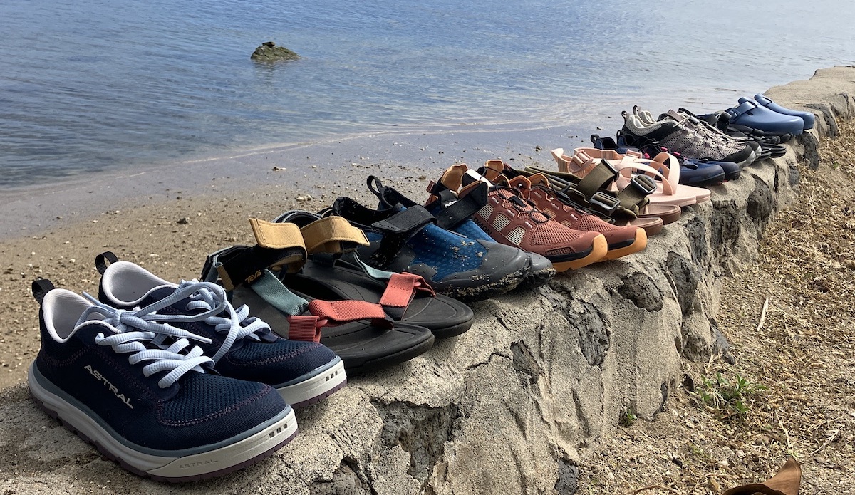 a row of water shoes lined up on a brick wall with water in the background