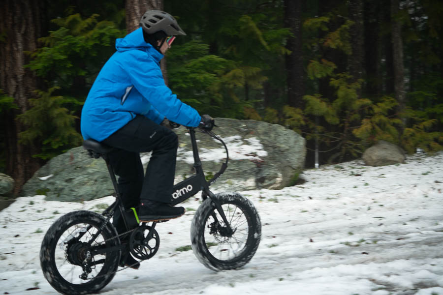 riding the oraimo scrambler 100 electric bike uphill in the snow