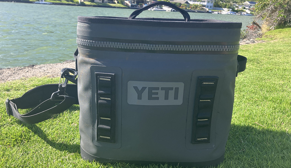 The Yeti Hopper Flip 12 cooler on a grassy bank next to the water