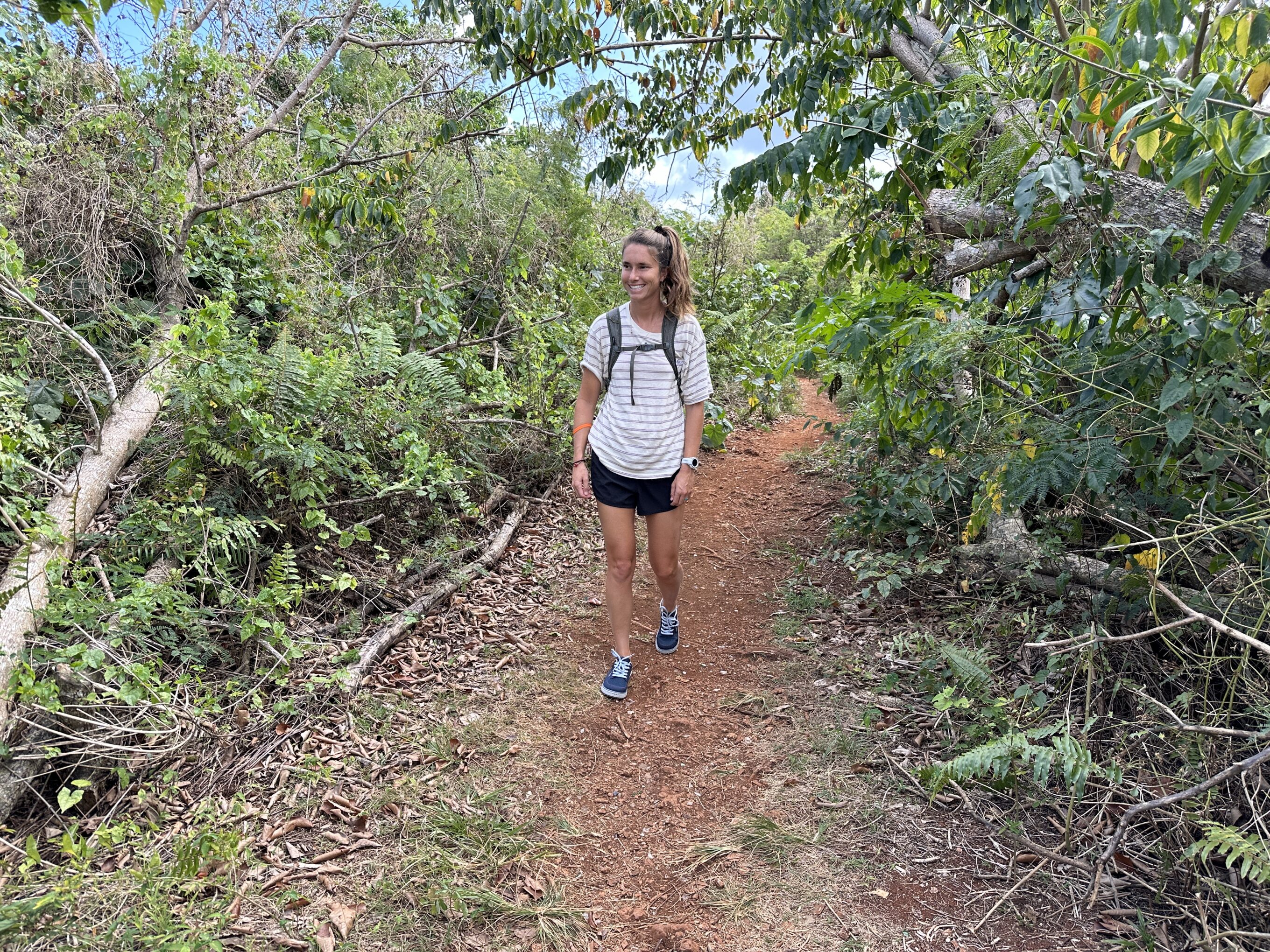 a woman walks down a trail while wearing astral brewess 2.0 water shoes