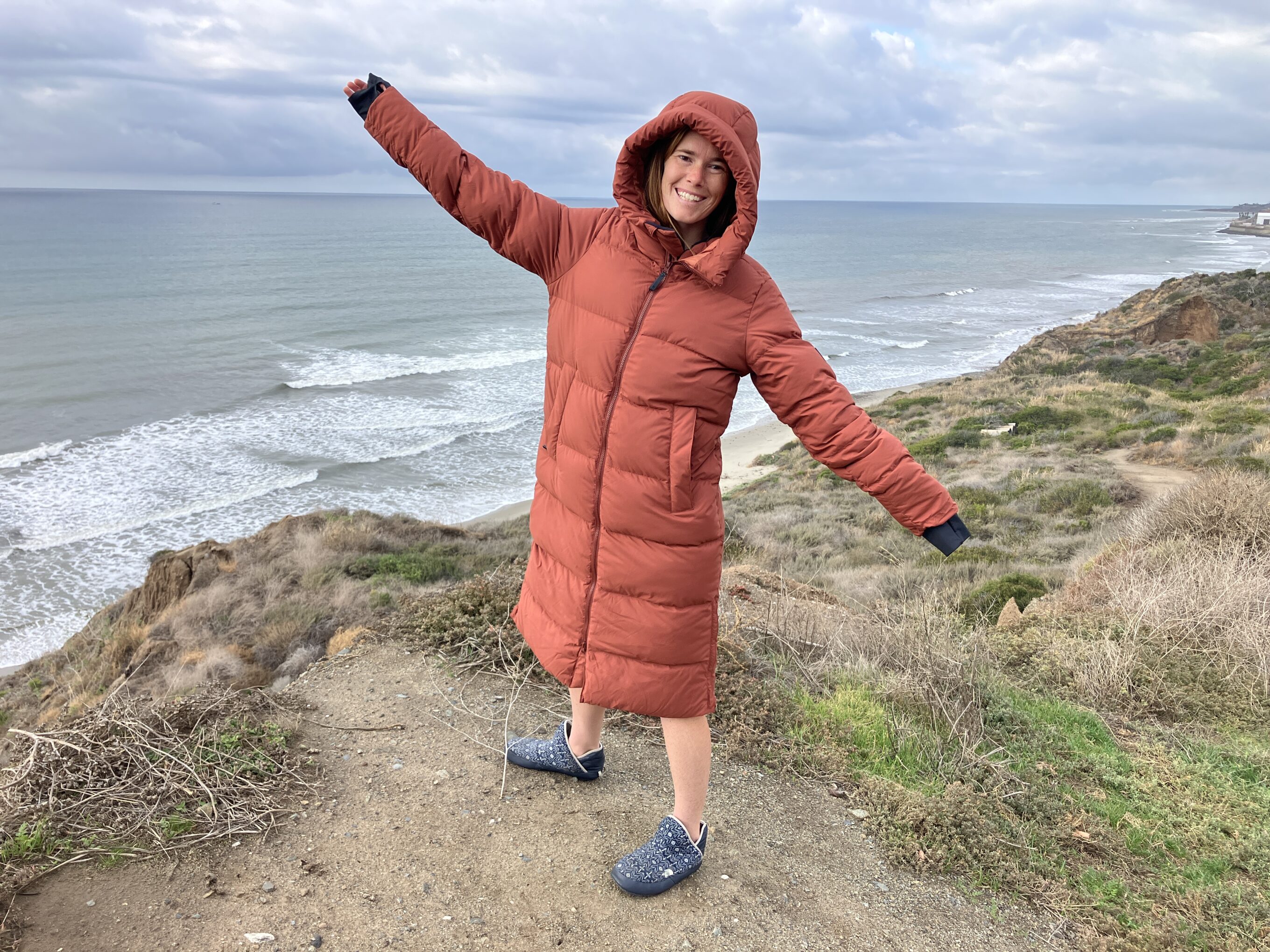 happy women on the beach in a puffer jacket