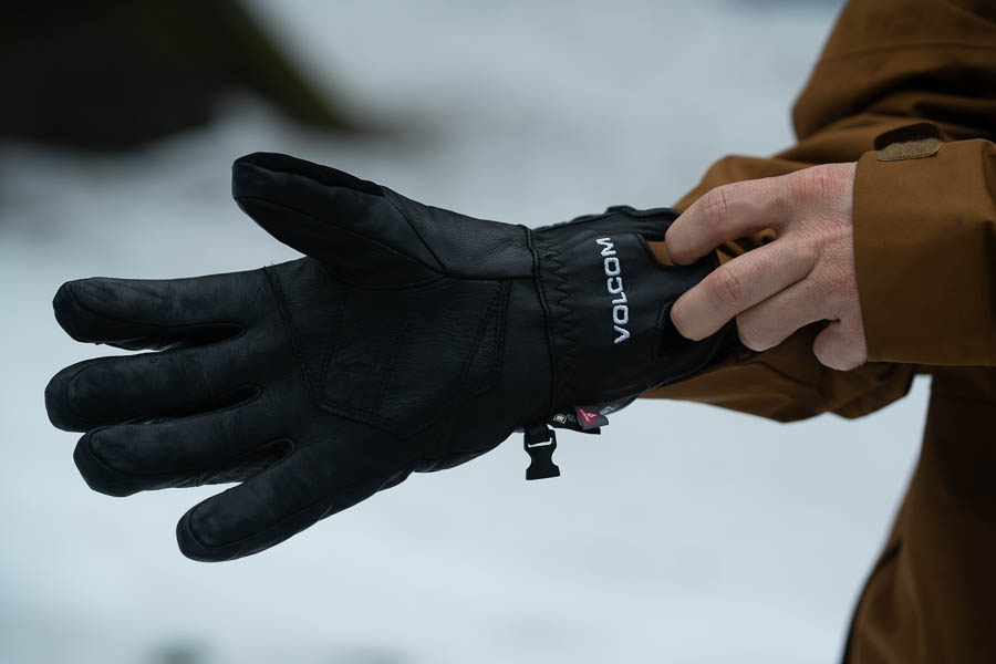 a person putting on the Volcom Service snowboarding gloves