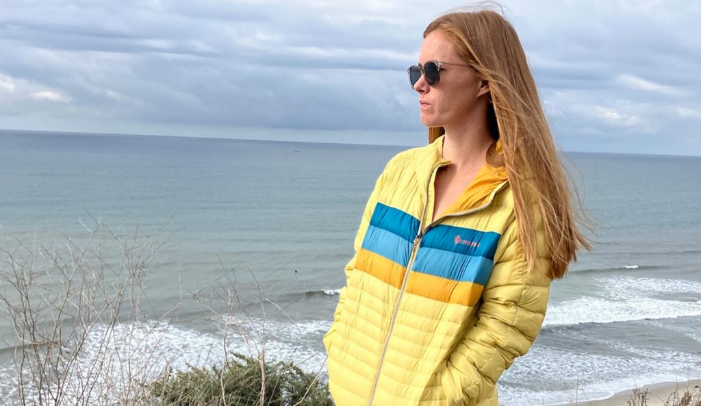 a woman wearing the Cotopaxi Fuego Down Hoodie