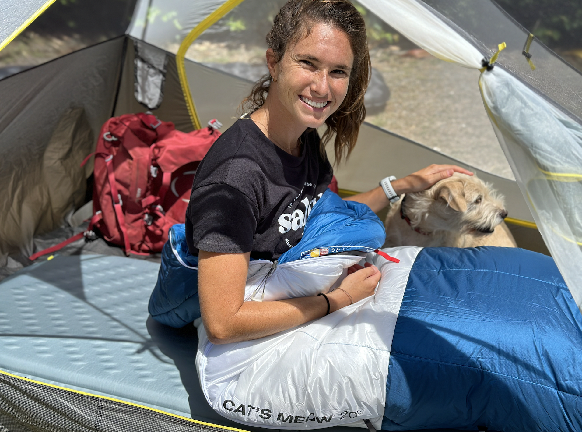 a woman and a dog in a backpacking tent