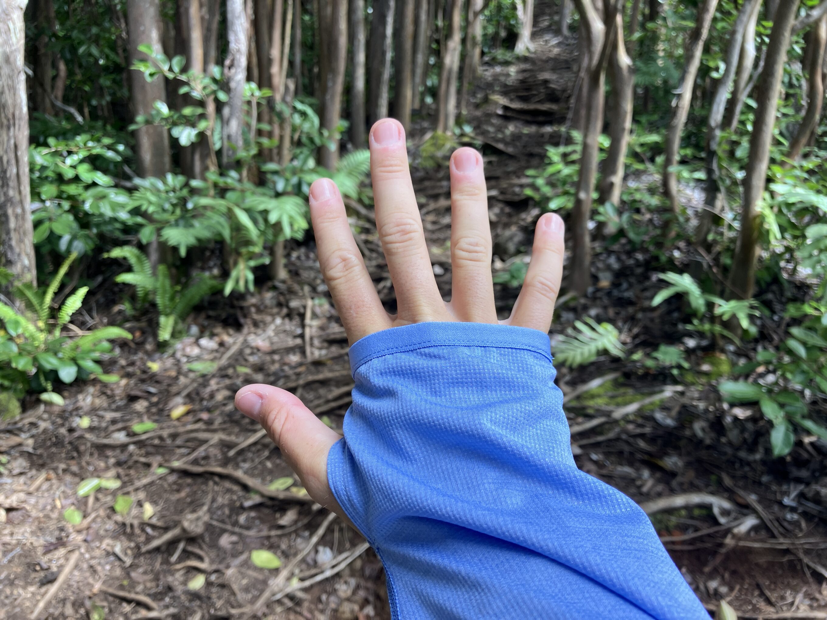 a close up of a hand through a thumb loop in a sun shirt