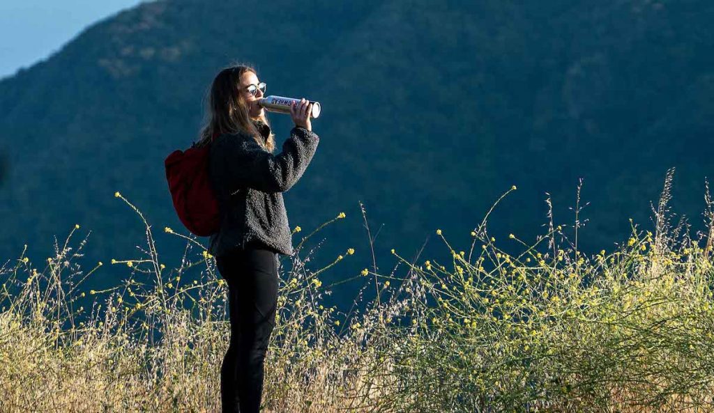 A female hiker drinking Arrowhead