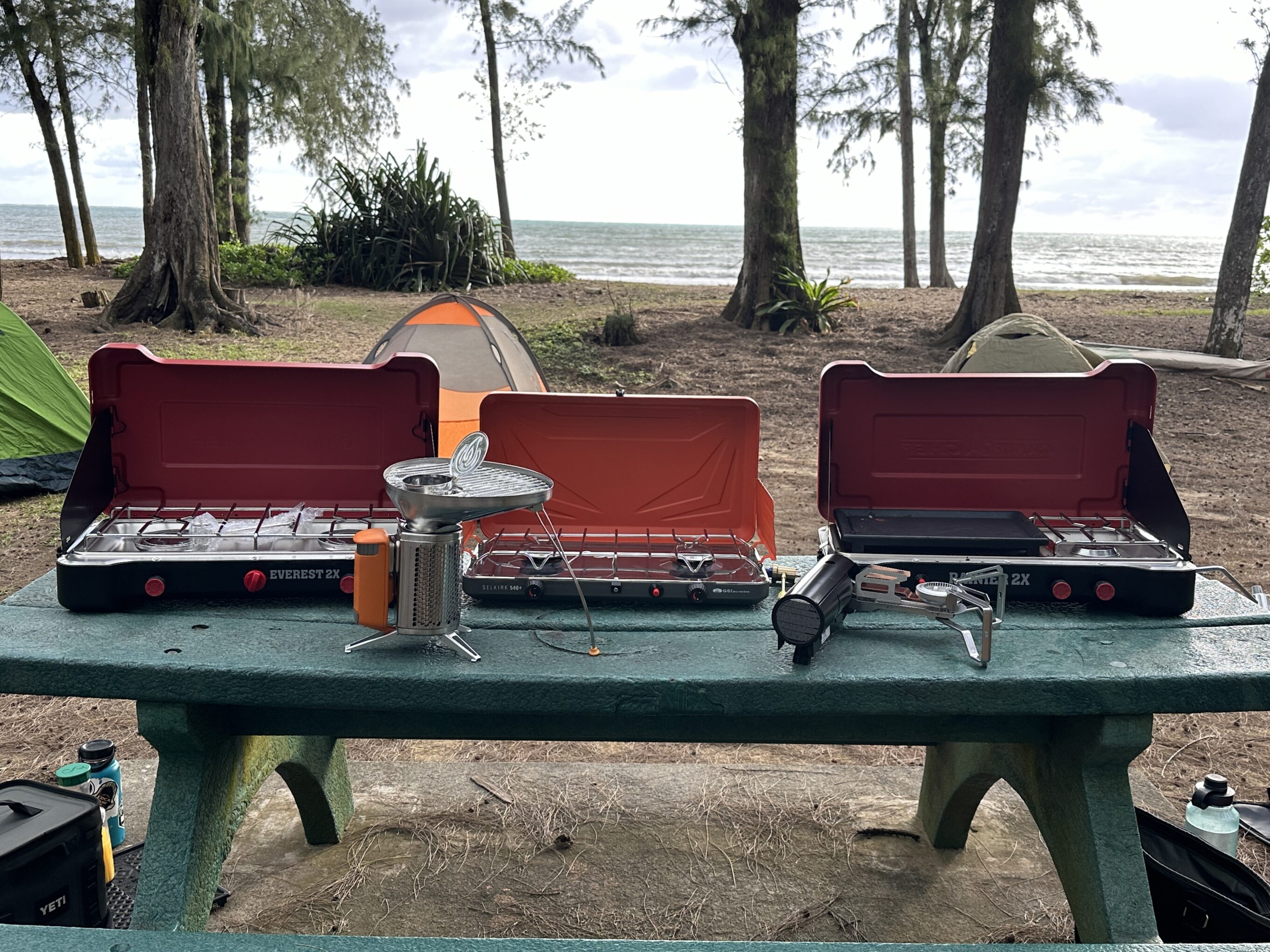 a bunch of camping stoves on a bench