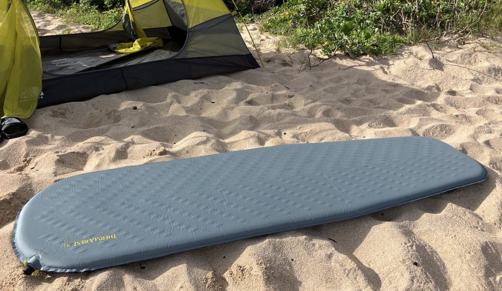 therm-a-rest sleeping pad on the sand in front of a tent