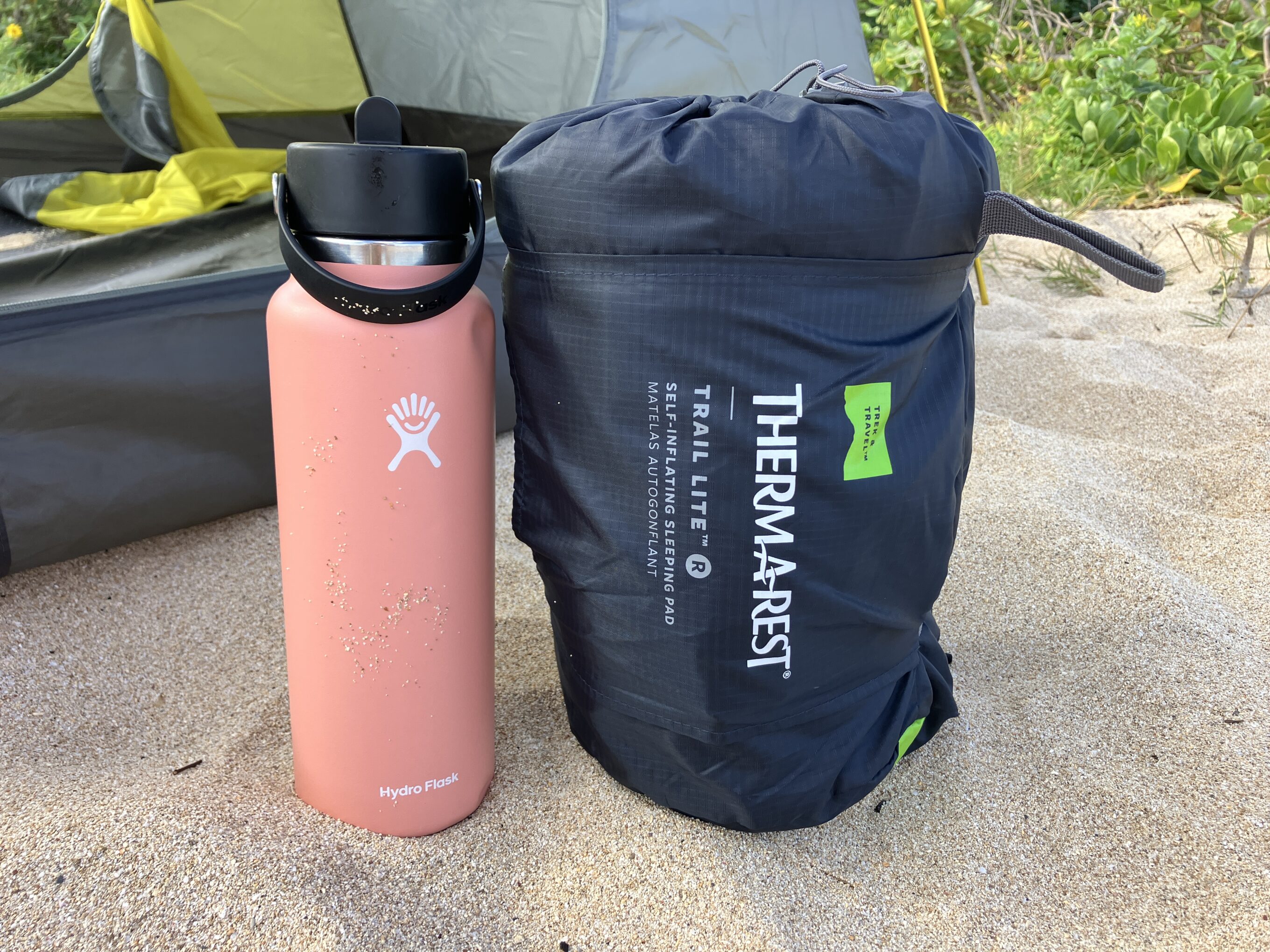 a packed therm-a-rest next to a water bottle 