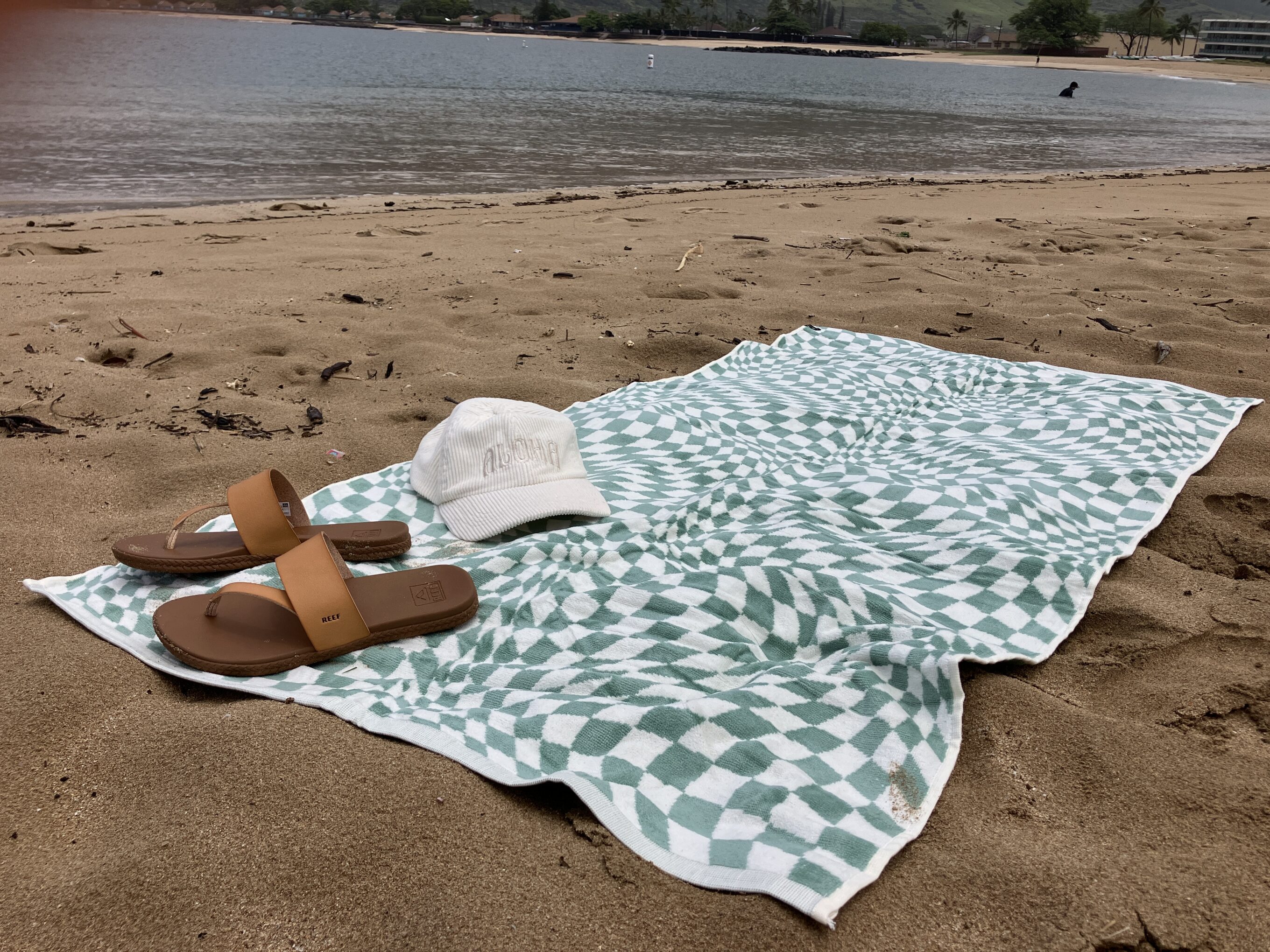 sandals sitting on a towel at the beach