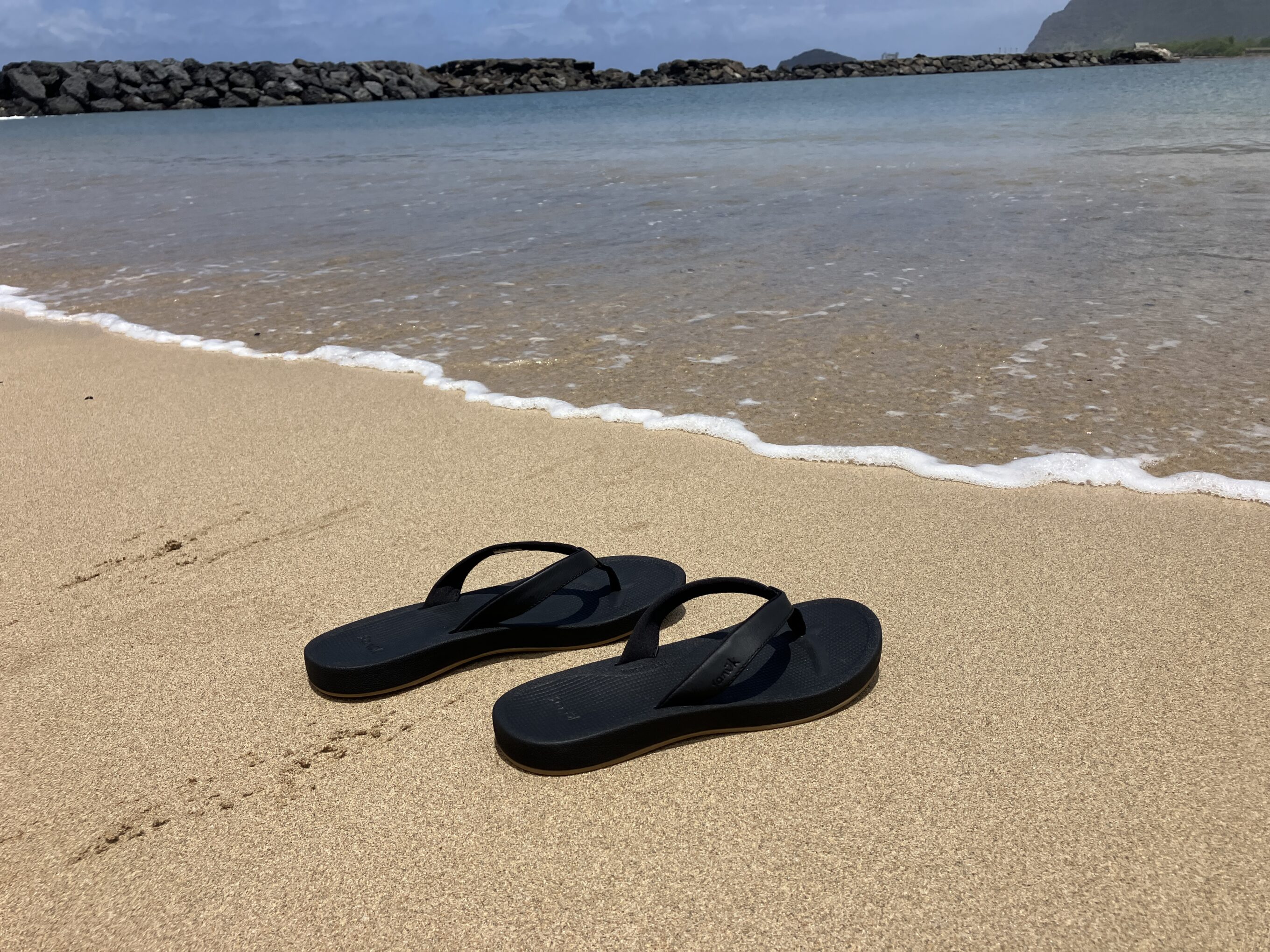 a pair of sandals on the beach