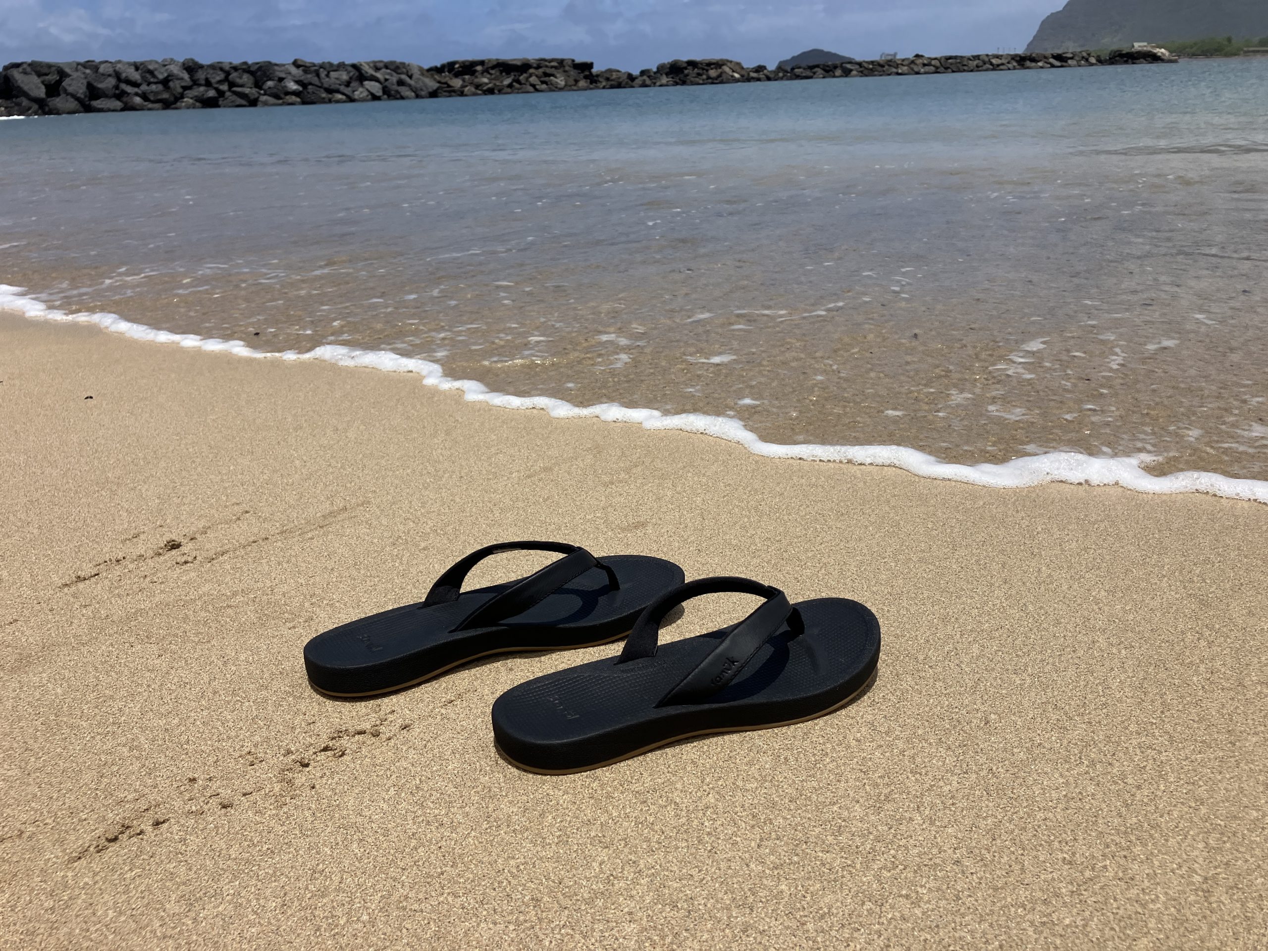 a pair of sandals on the beach
