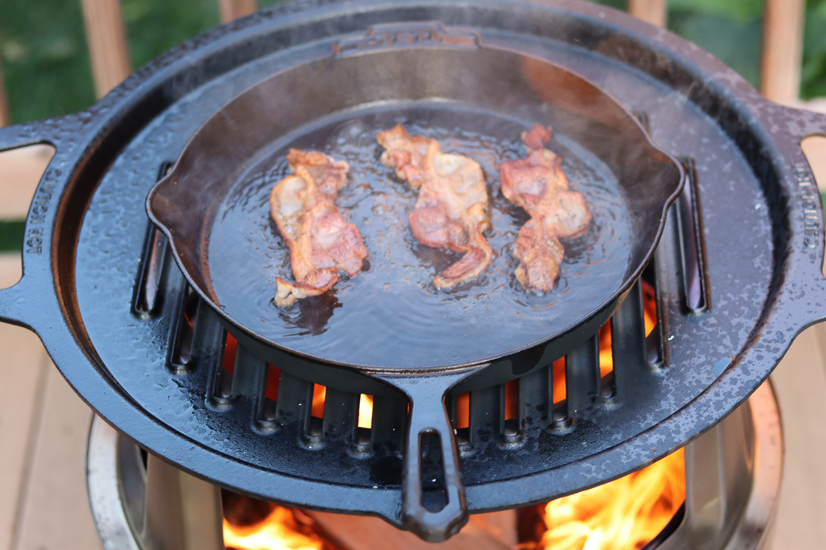 cooking bacon over a fire