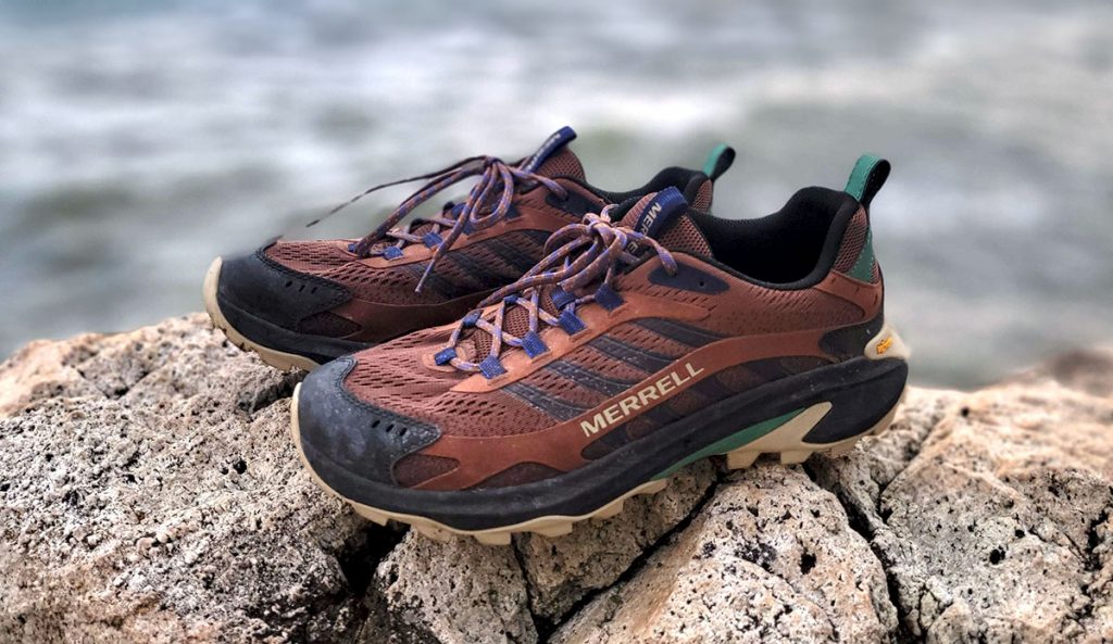 the Merrell Moab Speed 2 hiking shoes perched on a rock next to the ocean