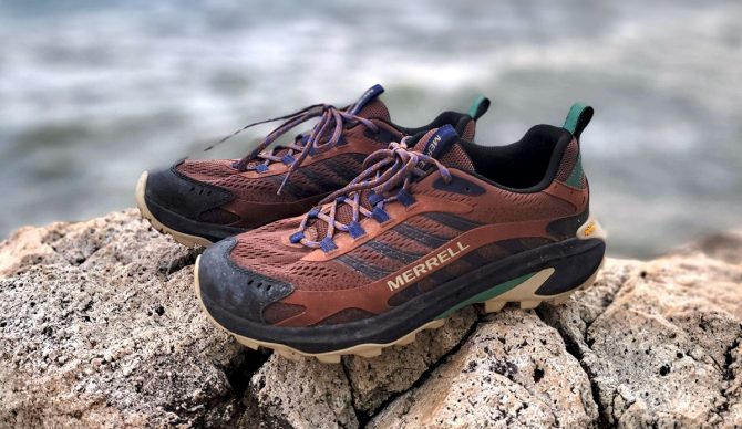 the Merrell Moab Speed 2 hiking shoes perched on a rock next to the ocean