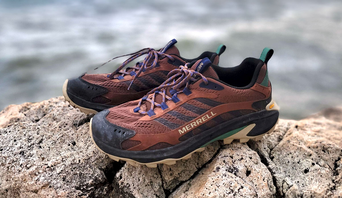 the Merrell Moab Speed 2 hiking shoes perched on a rock next to the ocean