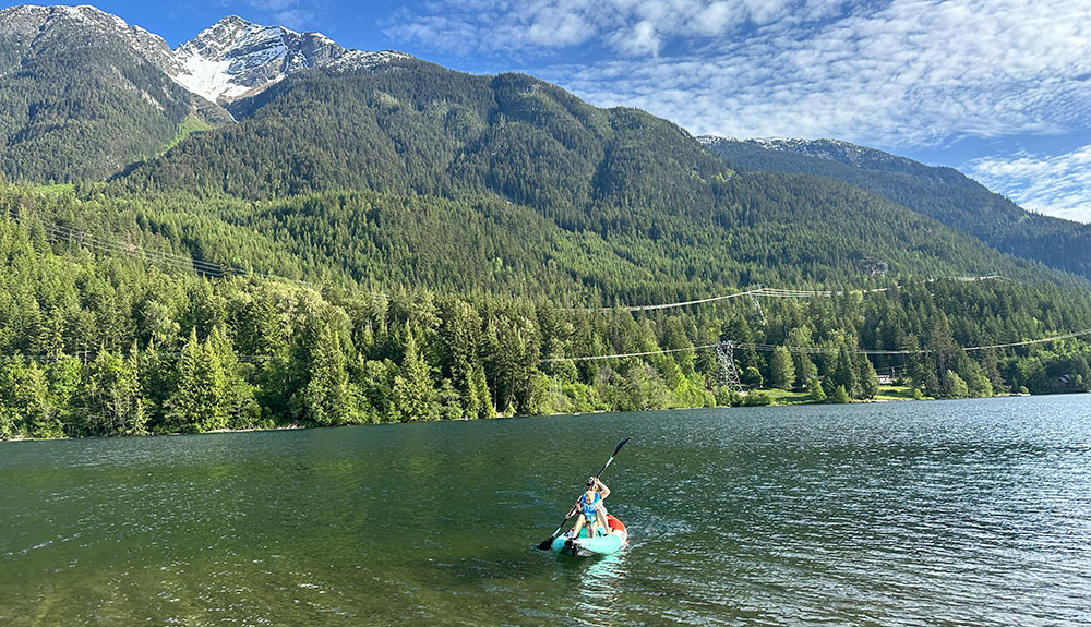 paddling the bote aero zeppelin under a large mountain peak
