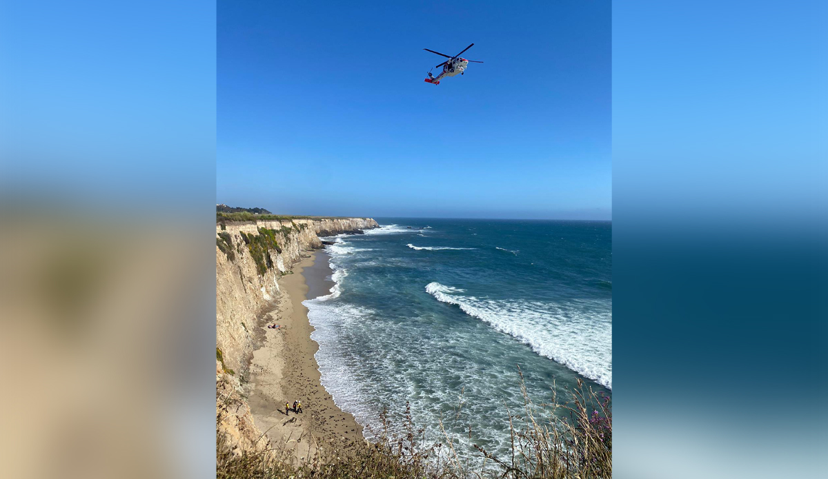 Photo of the stranded kite surfer, shortly before being rescued. His help sign can be seen in the sand. Photo: Cal Fire San Mateo – Santa Cruz Unit