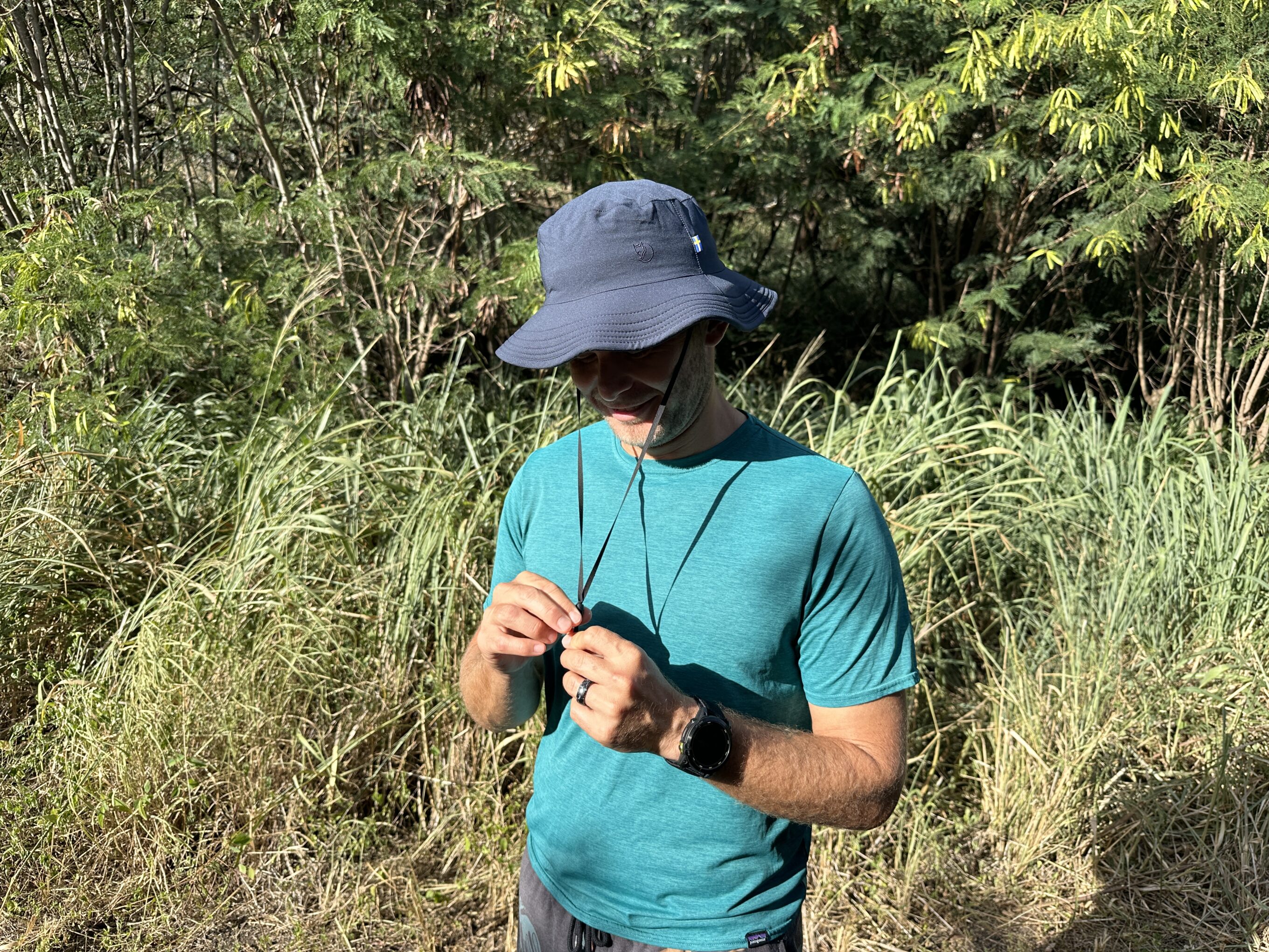 a man adjusting a sun hat