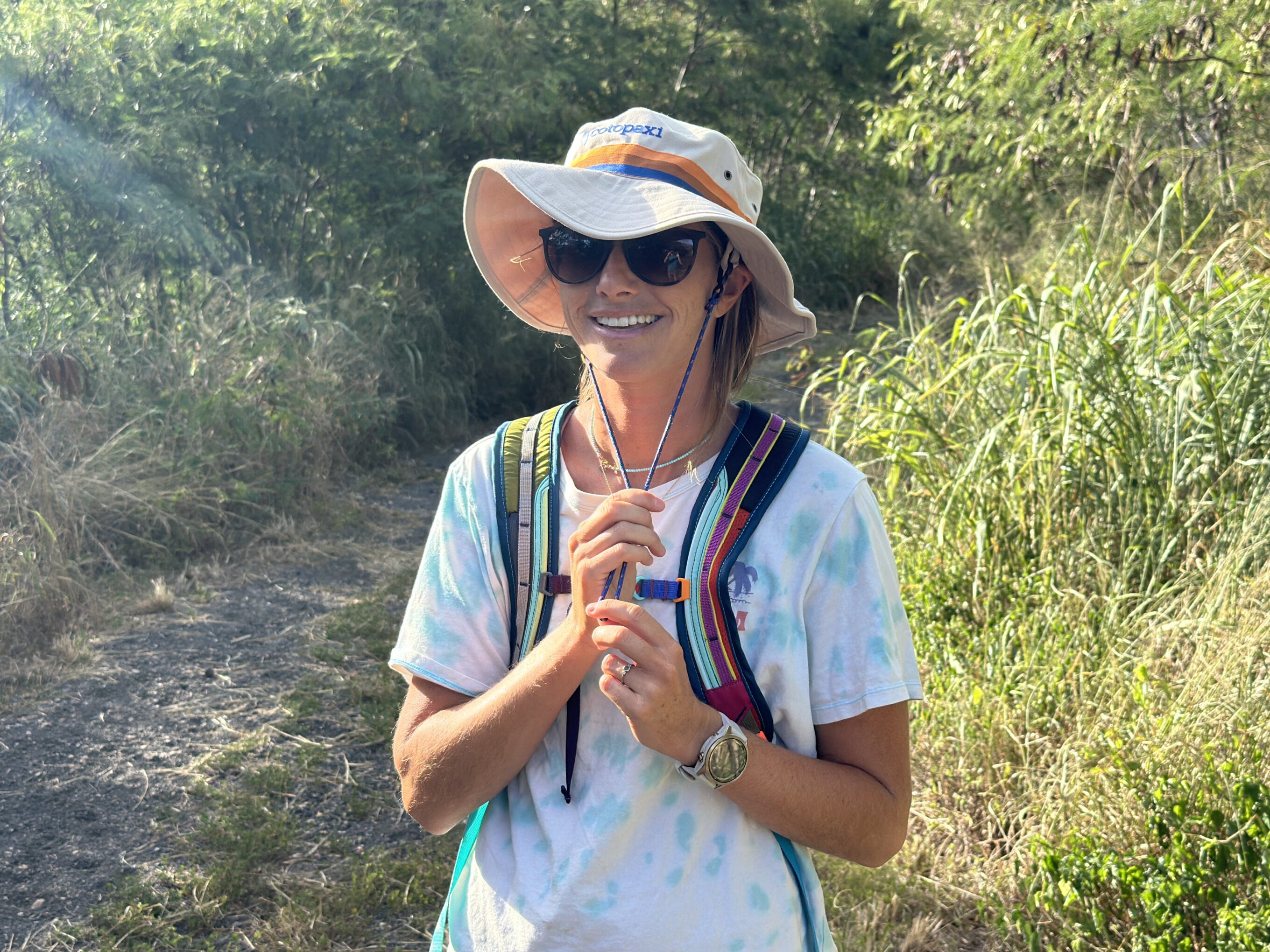 a woman adjusting her sun hat