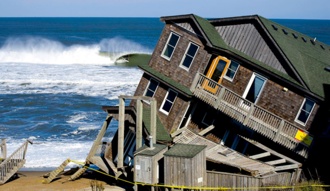 House falling into ocean with surfer getting barreled in background. Rodanthe, NC