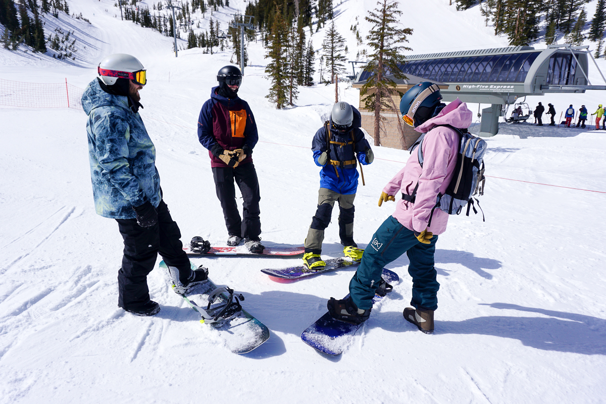 snowboarders standing around