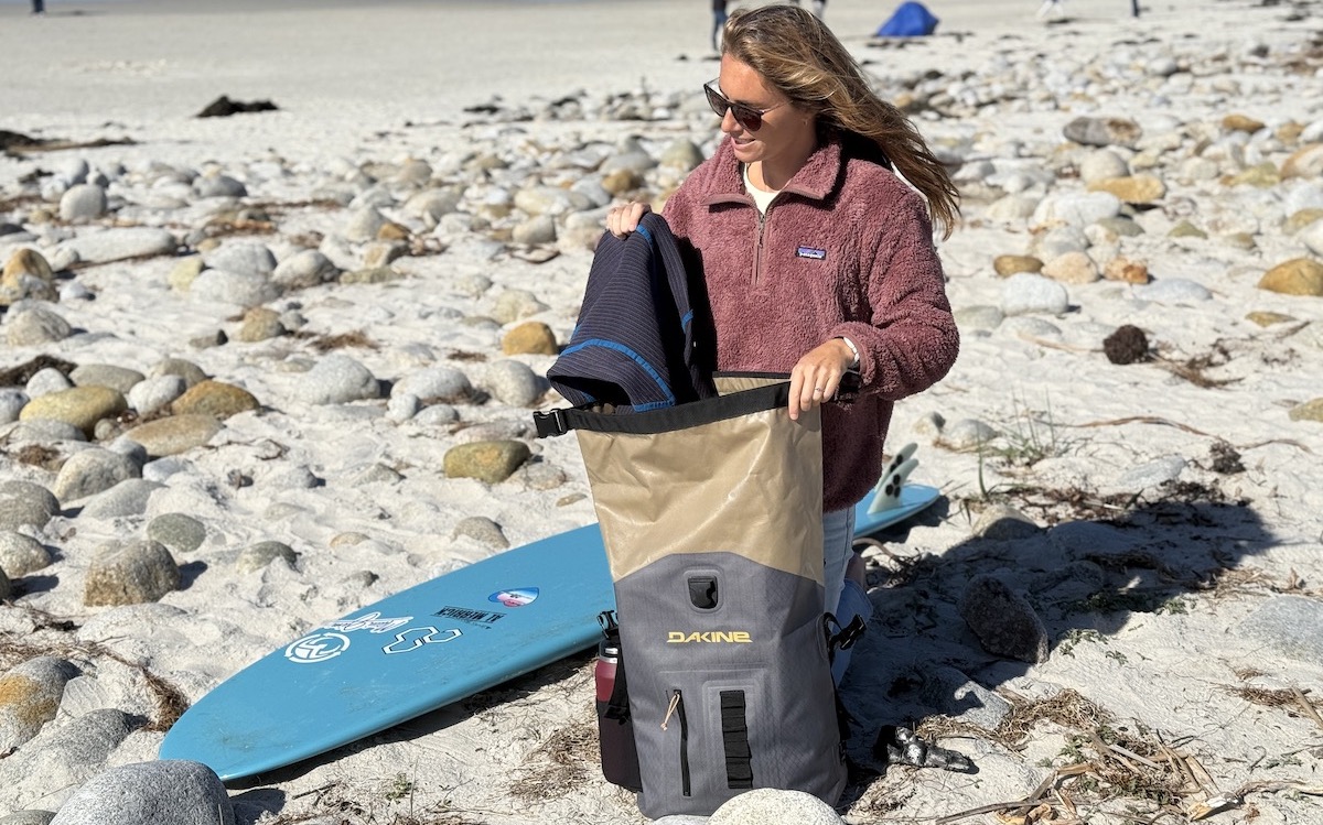 a woman at the beach with a Dakine Cyclone surf backpack