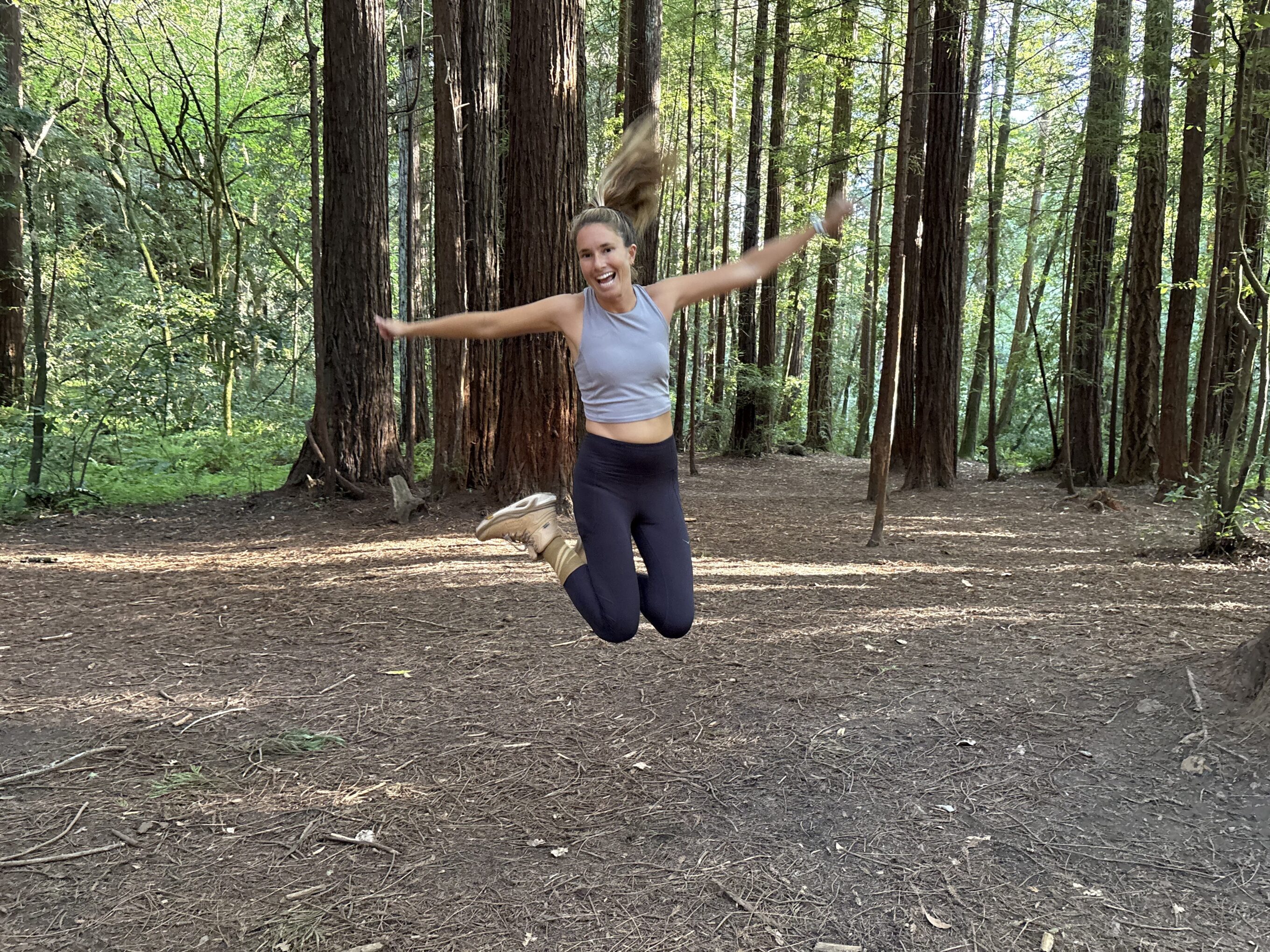 a woman jumping in the forest