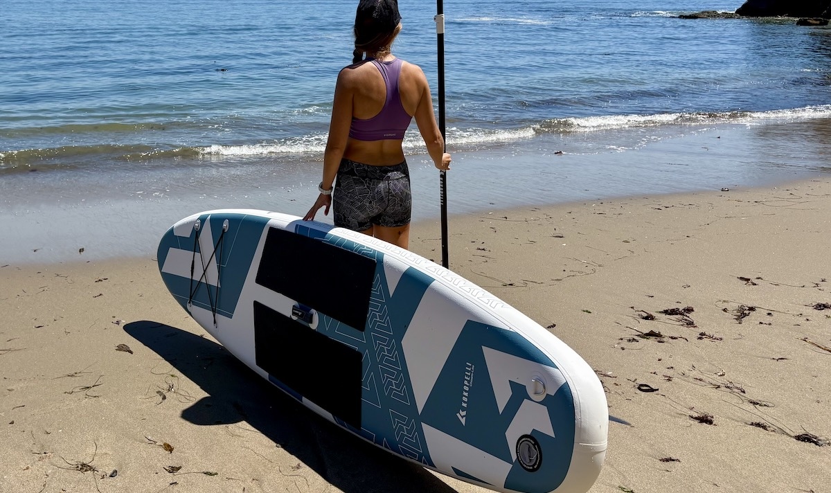 standing on the beach with the chasm-lite paddle board