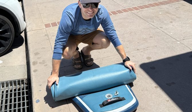 a man rolling up a paddle board