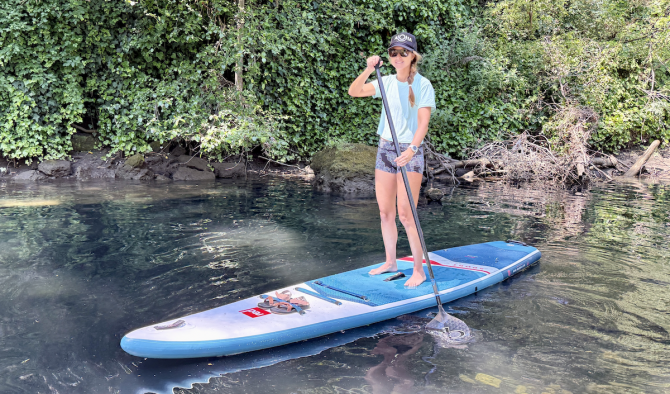 a woman paddling a sup on a river