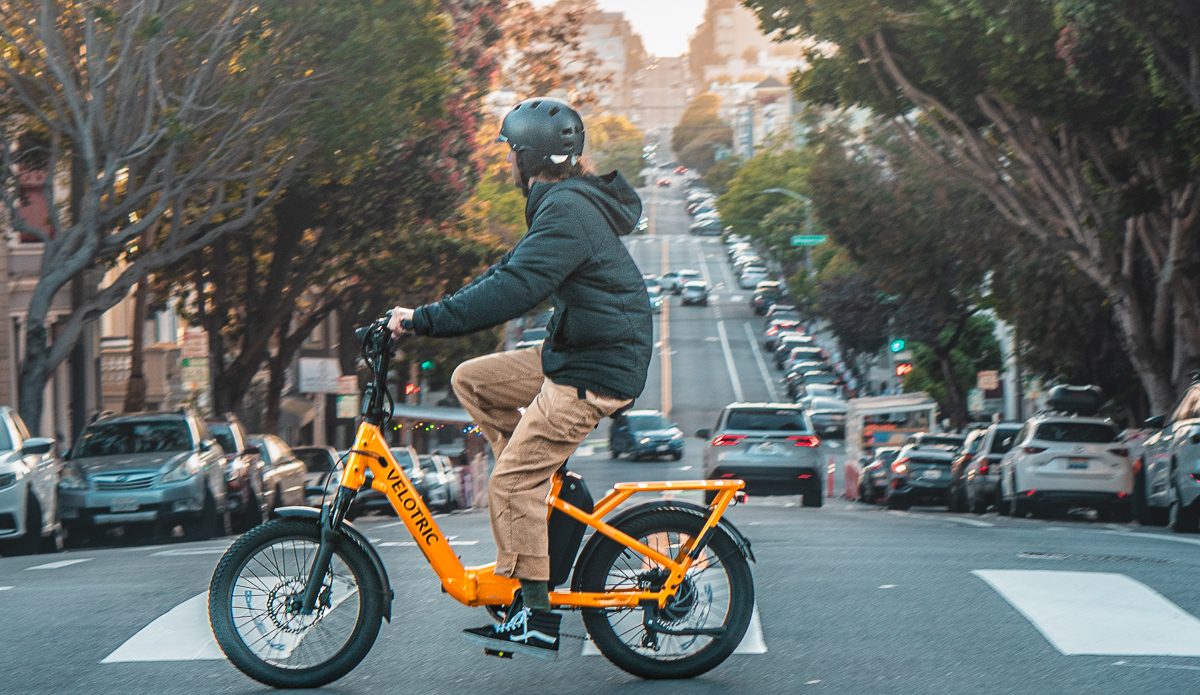 man riding ebike on busy street